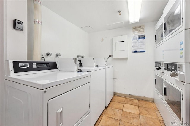 community laundry room featuring baseboards, stacked washing maching and dryer, and washing machine and dryer
