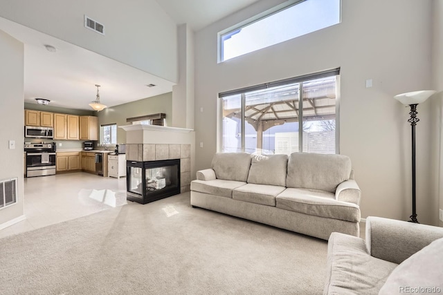 living room featuring a high ceiling and a tile fireplace