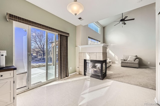 living room with light carpet, ceiling fan, lofted ceiling, and a tiled fireplace