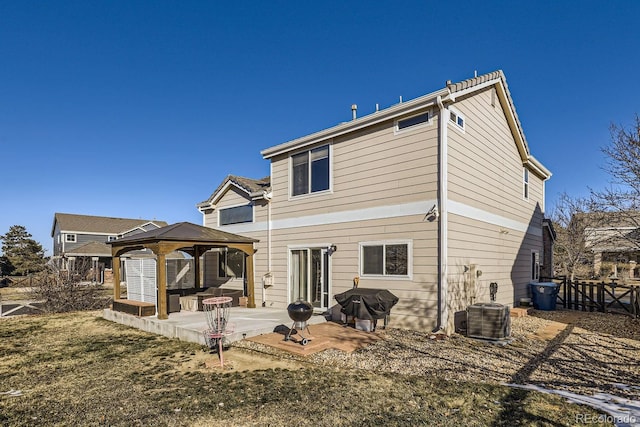 rear view of house featuring central air condition unit, a gazebo, a yard, and a patio