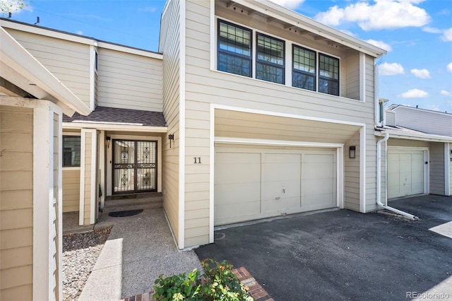 1011 Pierce St Unit 11, Lakewood, CO 80214 - view of front of house with a garage, driveway, and a shingled roof
