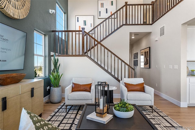 living room featuring light hardwood / wood-style floors and a high ceiling