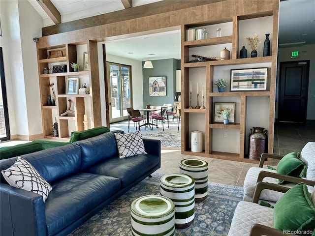 living room featuring beamed ceiling and built in shelves