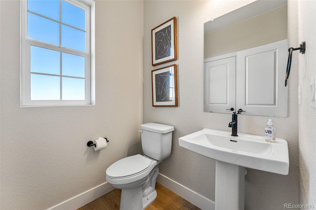 bathroom with hardwood / wood-style flooring and toilet