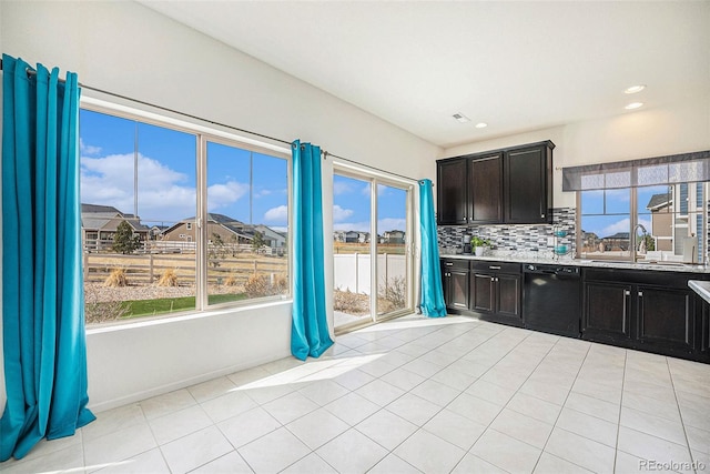 kitchen featuring light tile patterned floors, black dishwasher, light countertops, a sink, and decorative backsplash