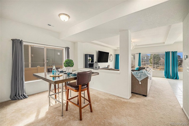dining space featuring light colored carpet, baseboards, and visible vents