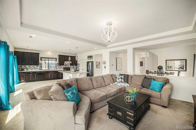 living area with a raised ceiling, light tile patterned floors, a notable chandelier, and recessed lighting