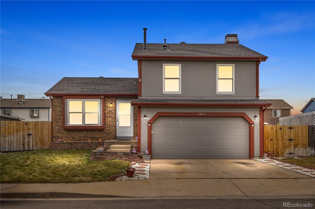 view of property featuring a garage and a front lawn