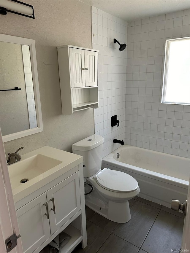 full bathroom with tile patterned floors, vanity, toilet, and tiled shower / bath combo