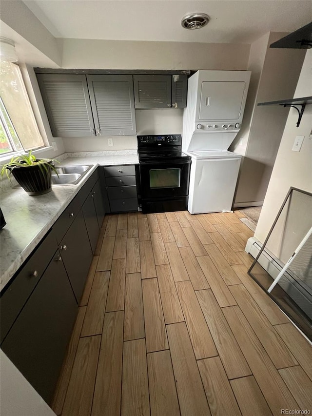 kitchen with stacked washer and dryer, sink, gray cabinets, and black electric range