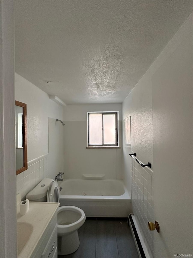 full bathroom with tile walls, vanity, a textured ceiling, shower / washtub combination, and toilet