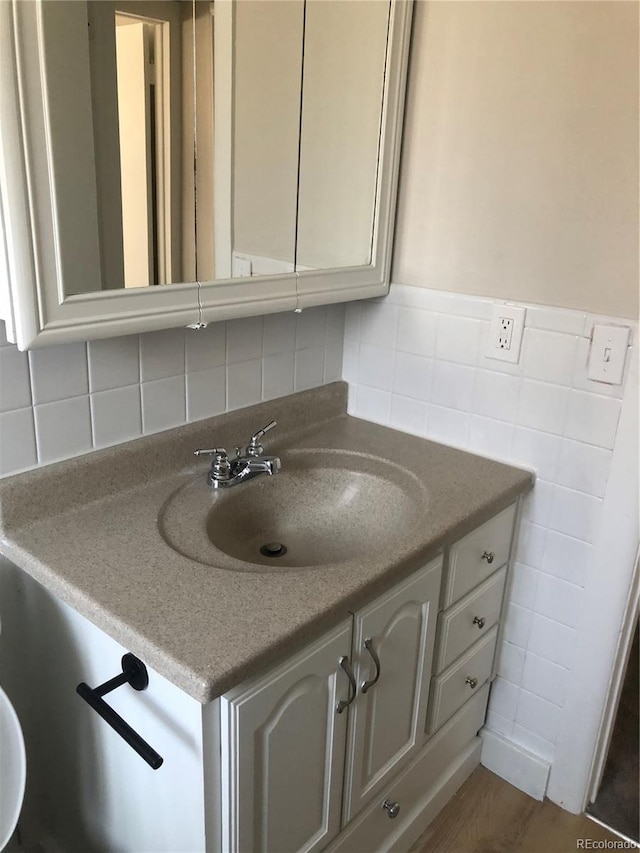 bathroom featuring vanity, wood-type flooring, and tile walls