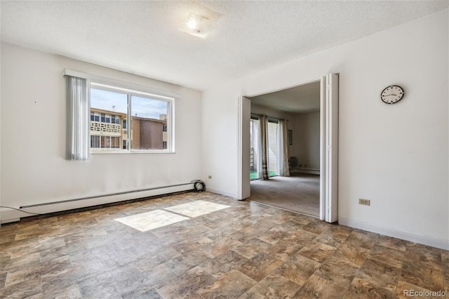 unfurnished room featuring a healthy amount of sunlight, a textured ceiling, and baseboard heating