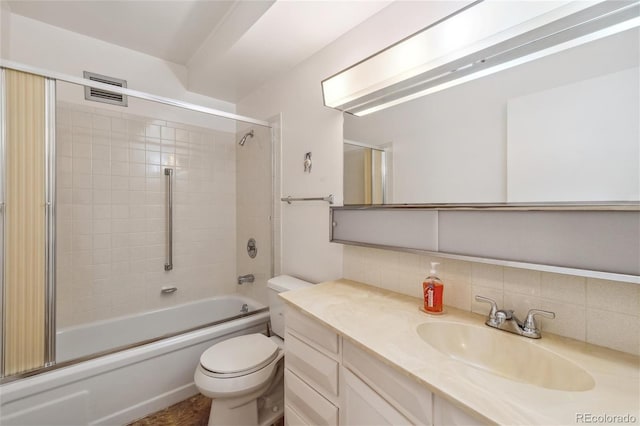 full bathroom with tasteful backsplash, enclosed tub / shower combo, vanity, and toilet