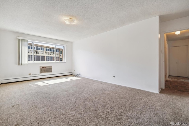 carpeted empty room with a baseboard radiator, a wall mounted air conditioner, and a textured ceiling