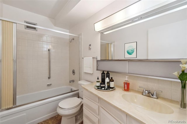 full bathroom featuring vanity, decorative backsplash, enclosed tub / shower combo, and toilet