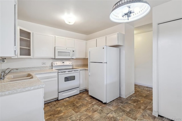 kitchen with white cabinetry, sink, and white appliances