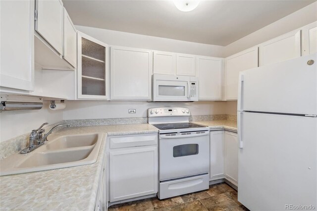 kitchen with white appliances, sink, and white cabinets