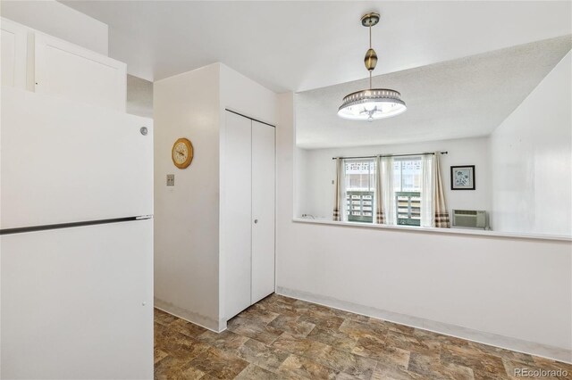 kitchen featuring white refrigerator, white cabinetry, and a wall mounted AC