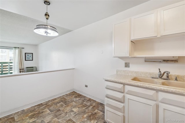 495 S Dayton St Unit 10C, Denver, CO 80247 - kitchen with light countertops, stone finish floor, a sink, decorative light fixtures, and baseboards