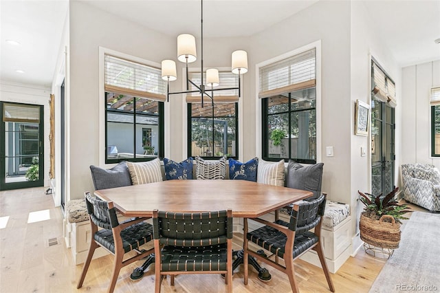 dining space with a notable chandelier and light hardwood / wood-style floors