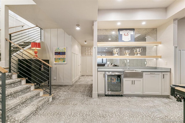 bar featuring white cabinetry, beverage cooler, and sink