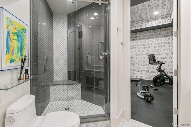 bathroom featuring a shower with shower door and toilet