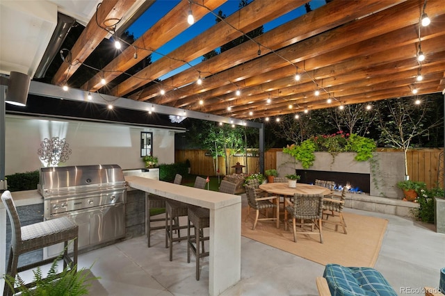 view of patio featuring a pergola, an outdoor kitchen, and grilling area