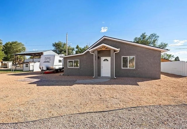 1820 E 3rd St, Pueblo, CO 81001 - ranch-style home featuring stucco siding, a storage unit, and a carport