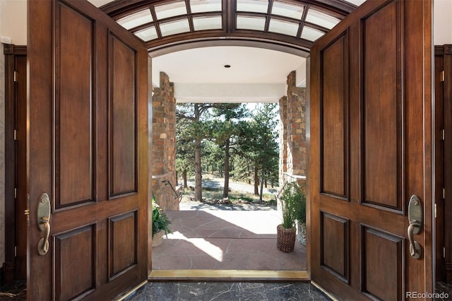 entryway featuring vaulted ceiling and brick ceiling