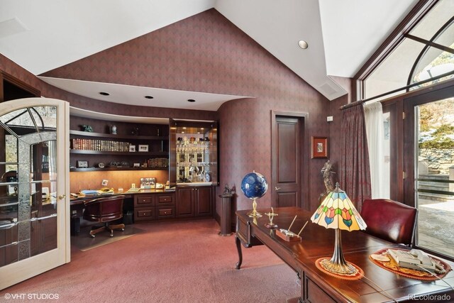 office space featuring carpet floors, built in desk, and lofted ceiling