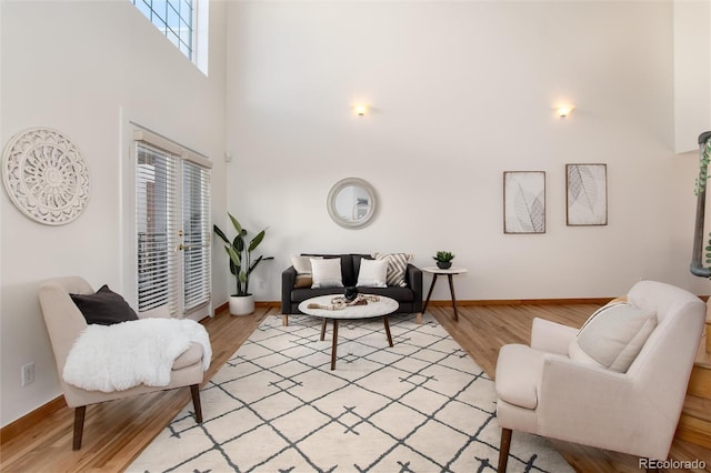 living room with a towering ceiling and light hardwood / wood-style floors