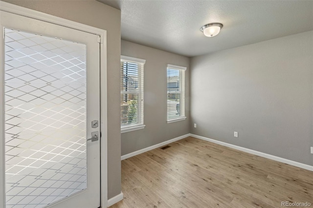 6154 Fiddle Way, Colorado Springs, CO 80925 - entryway featuring light wood finished floors and a textured ceiling