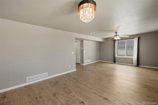 6154 Fiddle Way, Colorado Springs, CO 80925 - spare room with a ceiling fan, light wood-style floors, a chandelier, and a textured ceiling