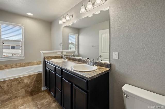 6154 Fiddle Way, Colorado Springs, CO 80925 - full bathroom with double vanity, a garden tub, and a textured wall