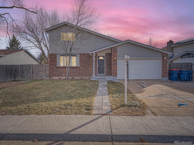 view of front of property with a garage and a lawn