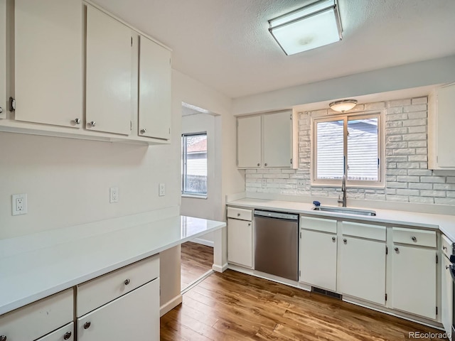 kitchen with white cabinetry, dishwasher, and sink