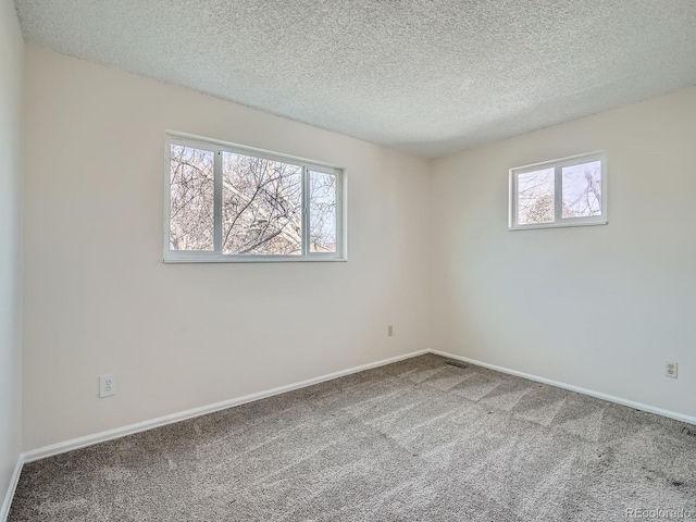 carpeted spare room with a textured ceiling