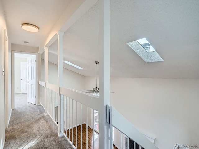 hall featuring lofted ceiling with skylight and carpet