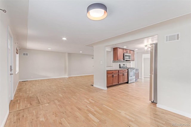 unfurnished living room featuring light wood finished floors, baseboards, and recessed lighting