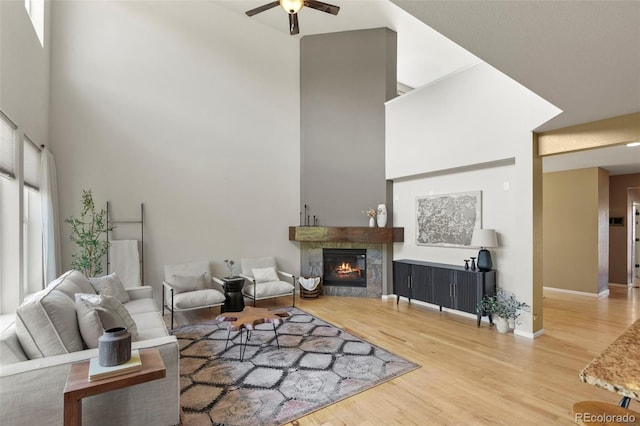 2815 Dreamcatcher Loop, Castle Rock, CO 80109 - living room with a ceiling fan, a towering ceiling, wood finished floors, and a premium fireplace
