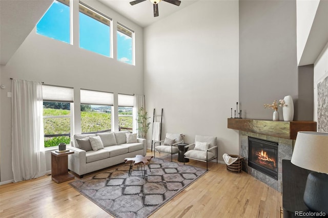 2815 Dreamcatcher Loop, Castle Rock, CO 80109 - living room featuring high vaulted ceiling, a ceiling fan, a tiled fireplace, wood finished floors, and plenty of natural light