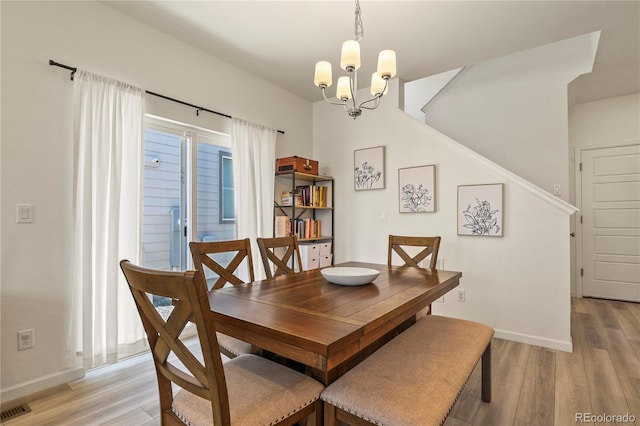 23920 E 34th Ave, Aurora, CO 80019 - dining area featuring light wood-style floors, a chandelier, stairs, and baseboards