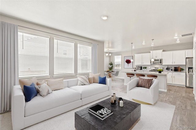 living area featuring light wood finished floors and a chandelier