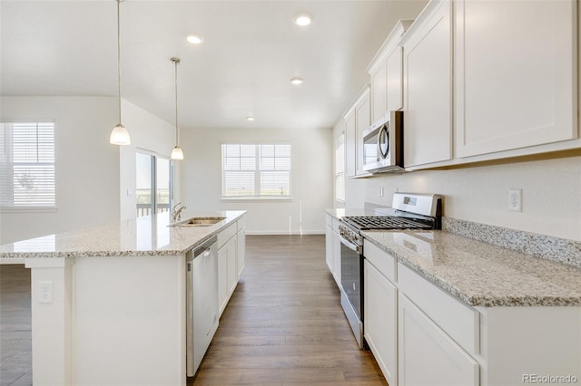 kitchen with stainless steel appliances, a sink, wood finished floors, an island with sink, and white cabinets