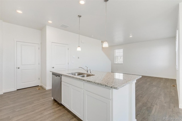 kitchen featuring a sink, stainless steel dishwasher, light wood-style floors, light stone counters, and recessed lighting