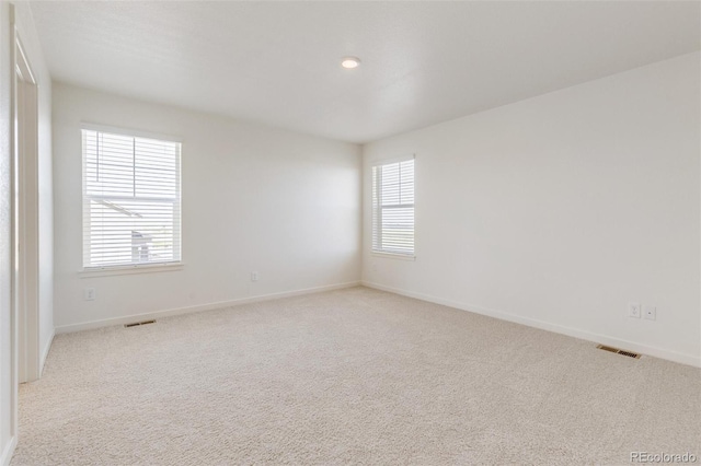 spare room featuring light colored carpet, baseboards, and recessed lighting