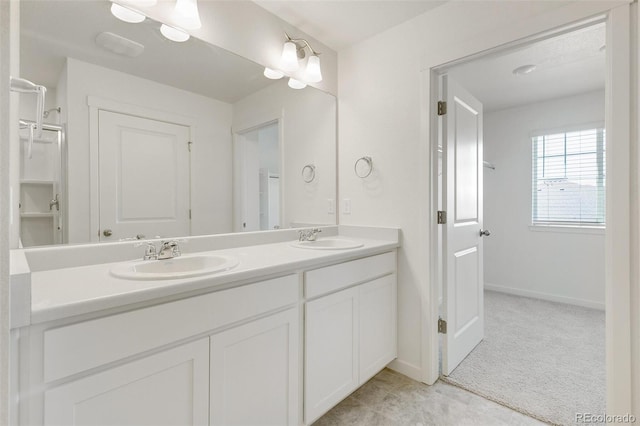bathroom with double vanity and baseboards