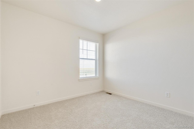 unfurnished room featuring light carpet and baseboards