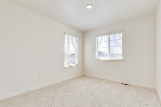 unfurnished room with light carpet and baseboards